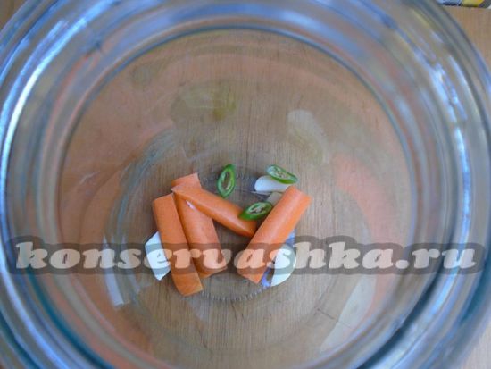 банку положите нарезанный чеснок, морковь и острый стручковый перец