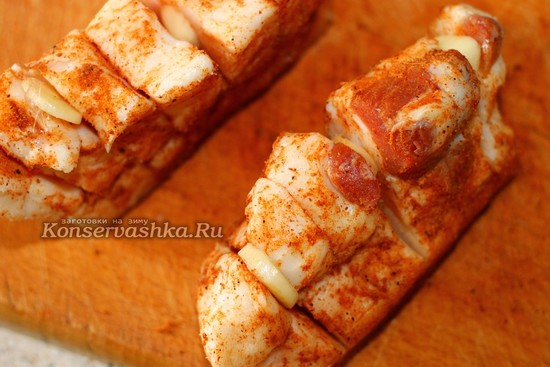 Вставьте пластинки чеснока в сало
